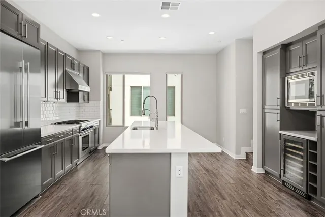 a kitchen with kitchen island stainless steel appliances a sink stove and refrigerator