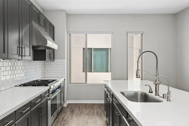 a kitchen with sink stove and cabinets