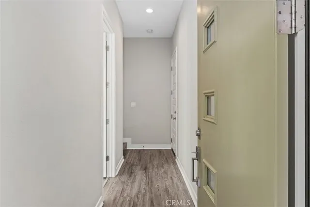 a view of a hallway with wooden floor and staircase