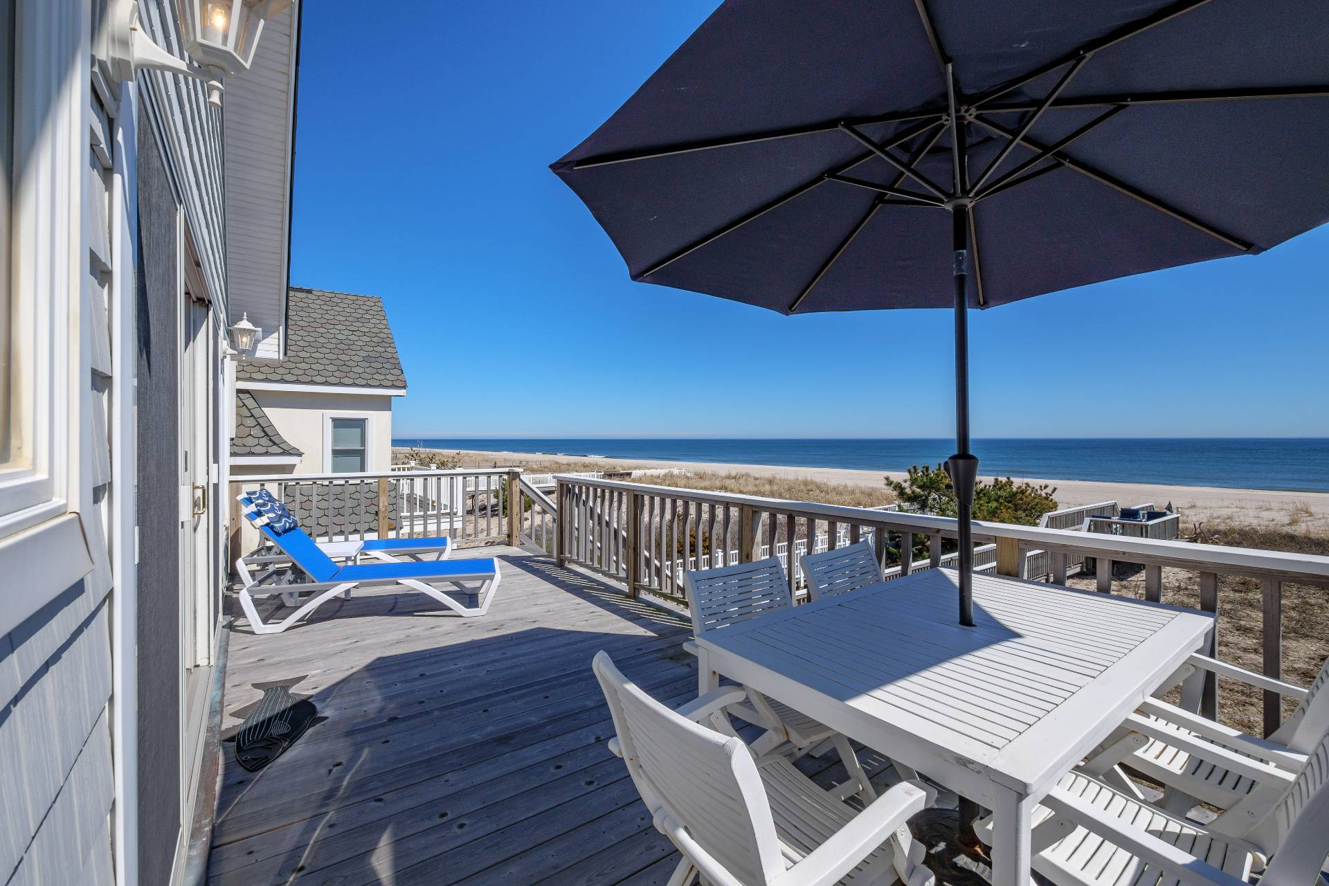 805 Dune Road Westhampton Beach, NY 11978 - Photo 23 of 25 an outdoor sitting area with furniture and umbrella