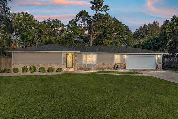 a view of a house with backyard and sitting area