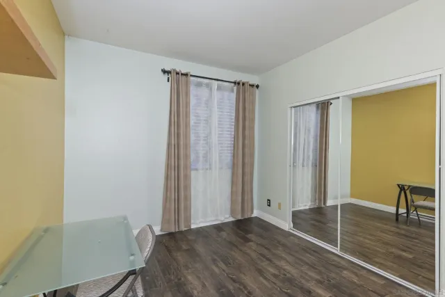 an empty room with wooden floor a chandelier and a fireplace