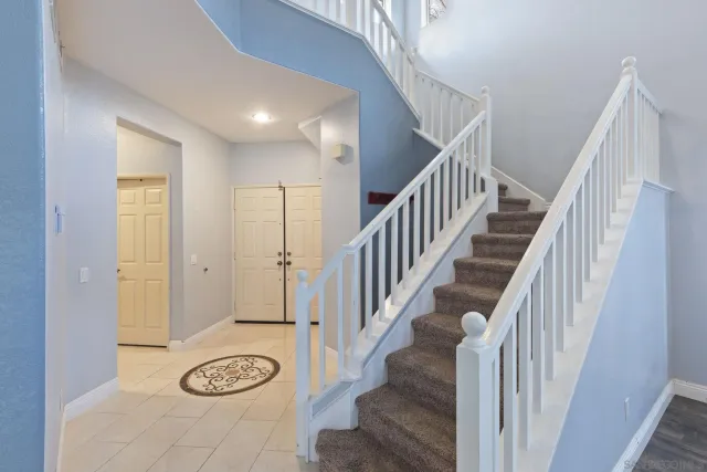 an empty room with wooden floor fireplace and windows