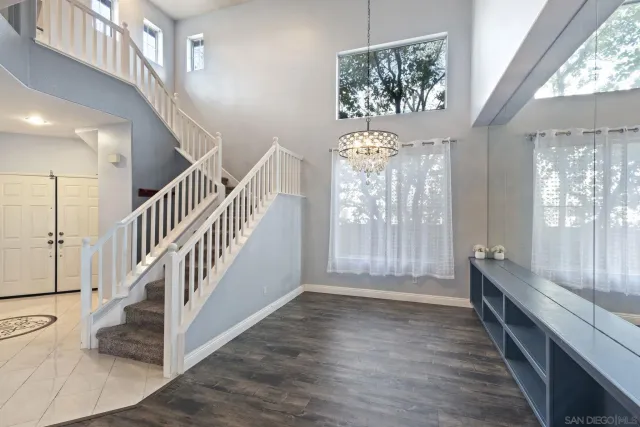 an empty room with windows a fireplace and wooden floor