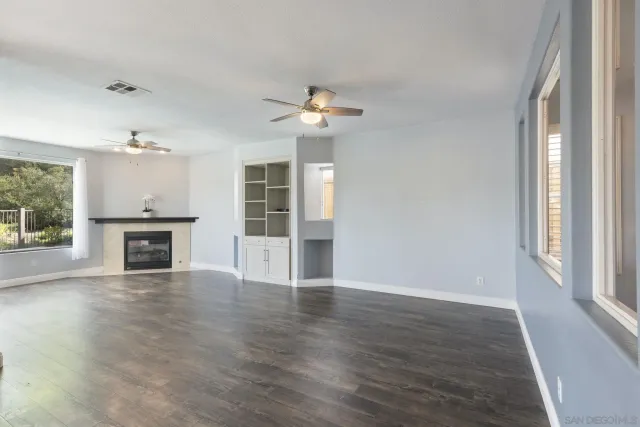 a view of a livingroom with furniture a ceiling fan and kitchen view