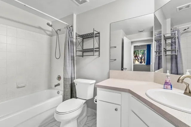 a bathroom with a sink toilet vanity and shower