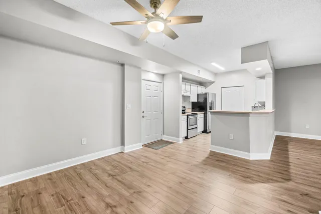 a view of a kitchen with a sink and a refrigerator