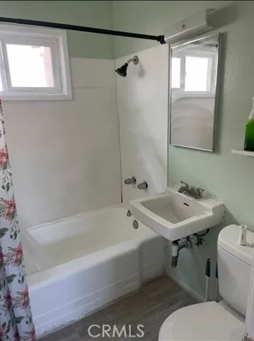 a bathroom with a sink and mirror with bathtub