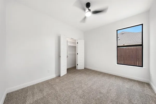 an empty room with a cabinet and mirrors