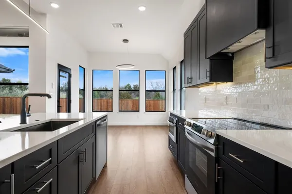 a kitchen with granite countertop a sink and a stove