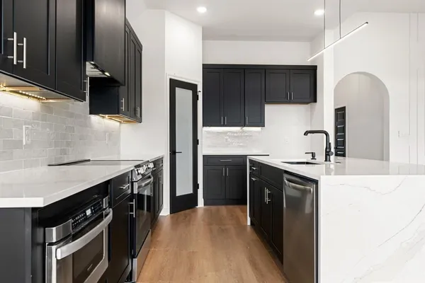 a kitchen with stainless steel appliances granite countertop a sink stove and refrigerator