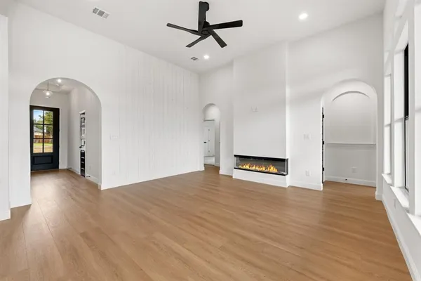 a view of a livingroom with wooden floor and a ceiling fan