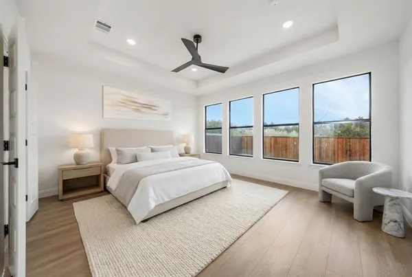 a spacious bedroom with a bed couch and a large window