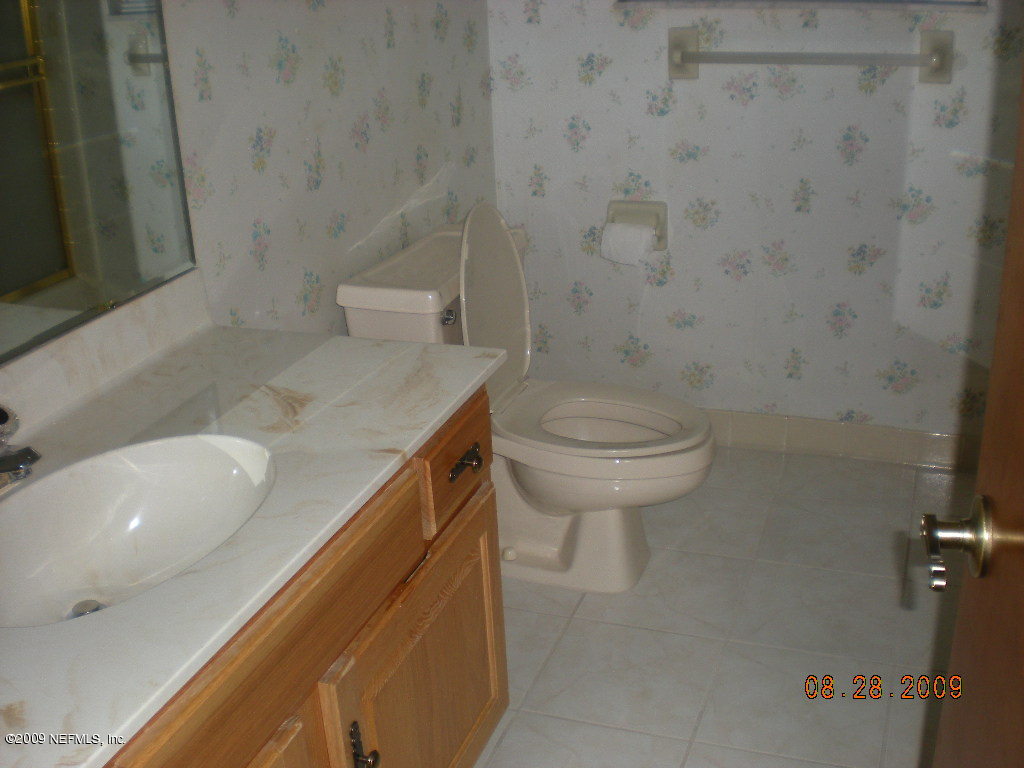 836 Orangewood Road St. Johns, FL 32259 - Photo 7 of 13 a bathroom with a sink a toilet and a mirror