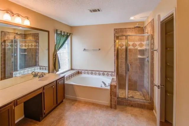 a bathroom with a tub sink shower and mirror