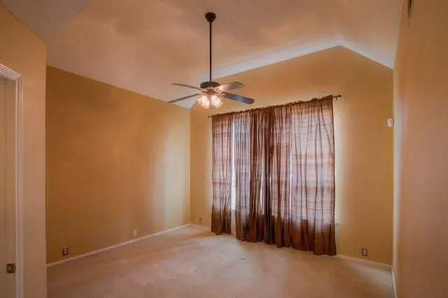 a view of a room with a ceiling fan and a window