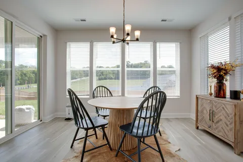 a dining room with furniture window and wooden floor