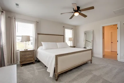 a spacious bedroom with a bed and a ceiling fan