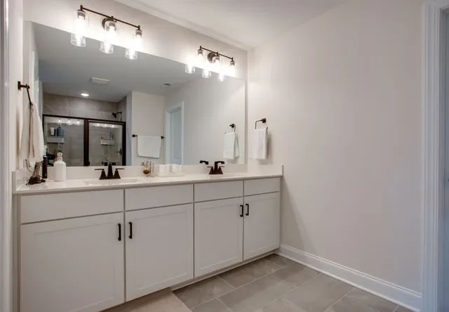 a bathroom with a double vanity sink and a mirror