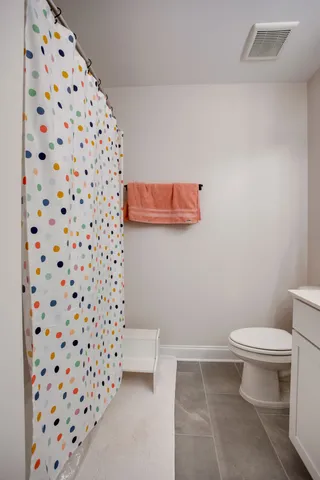 a white toilet sitting next to a shower curtain