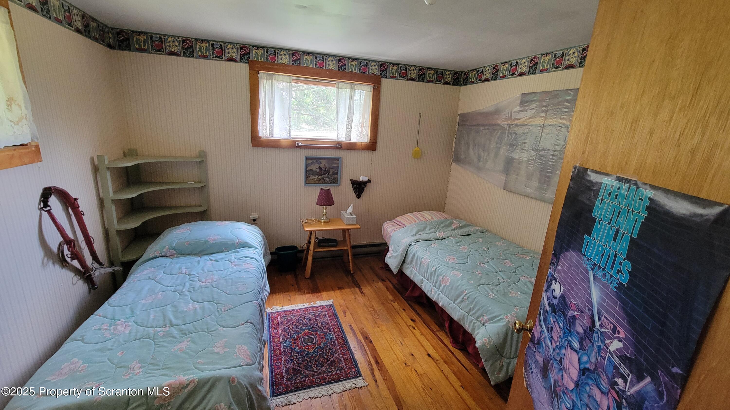 270 Starrucca Creek Road Starrucca, PA 18462 - Photo 23 of 51 a bedroom with a bed and a flat screen tv