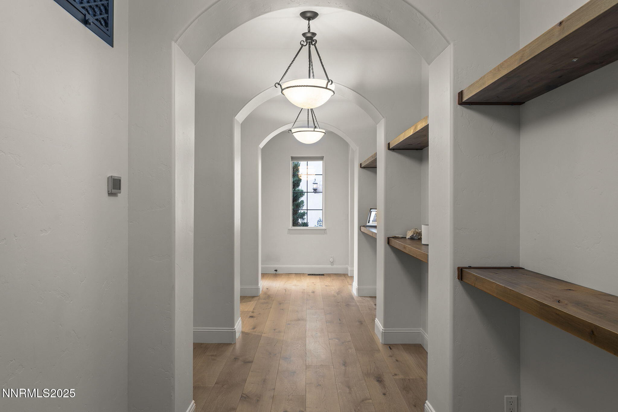 14220 Eagle Springs Court Reno, NV 89511 - Photo 34 of 57 a view of a hallway with wooden floor and a chandelier