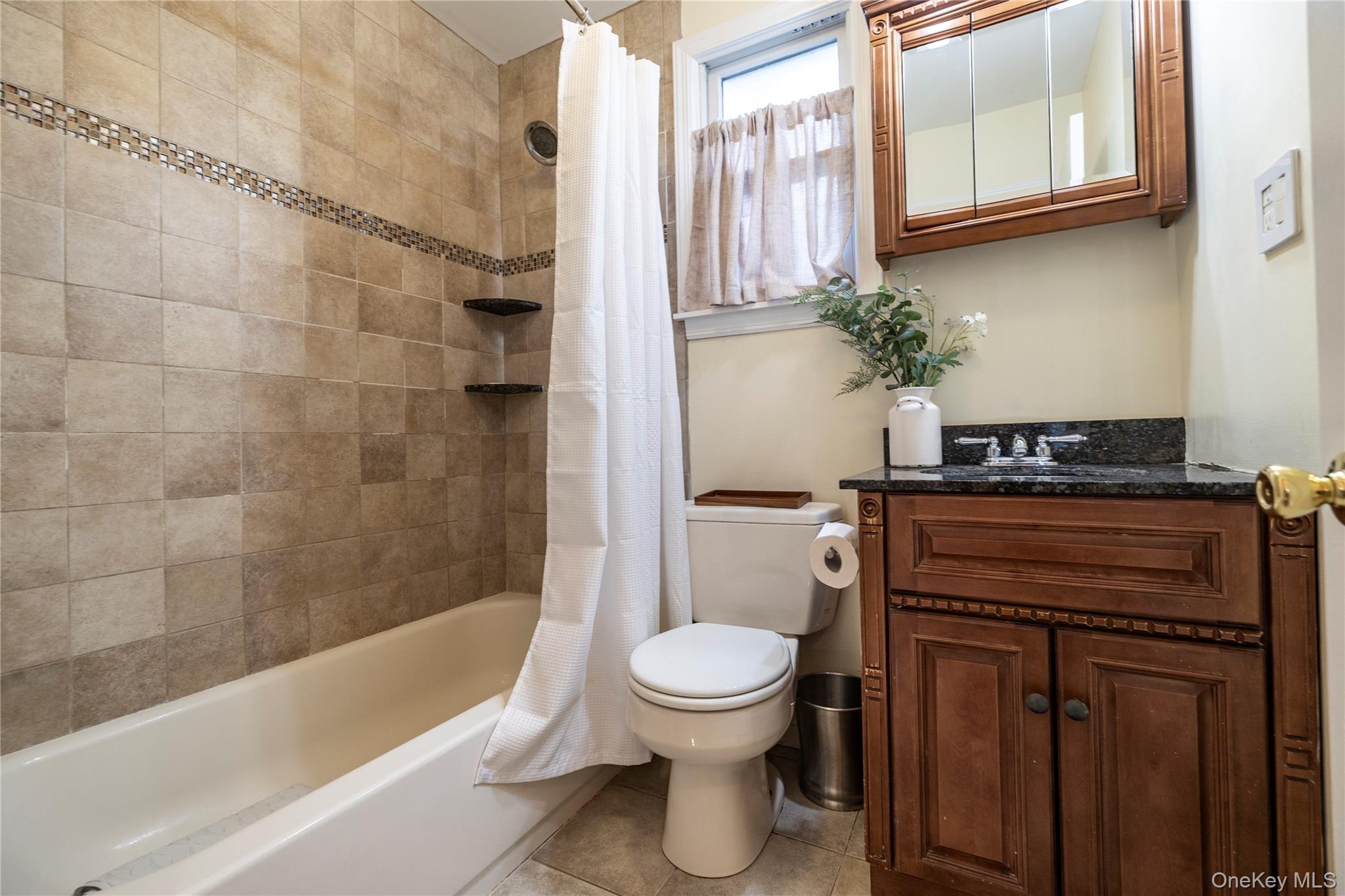 3016 Roxbury Road Oceanside, NY 11572 - Photo 13 of 24 a bathroom with a toilet a sink and bathtub