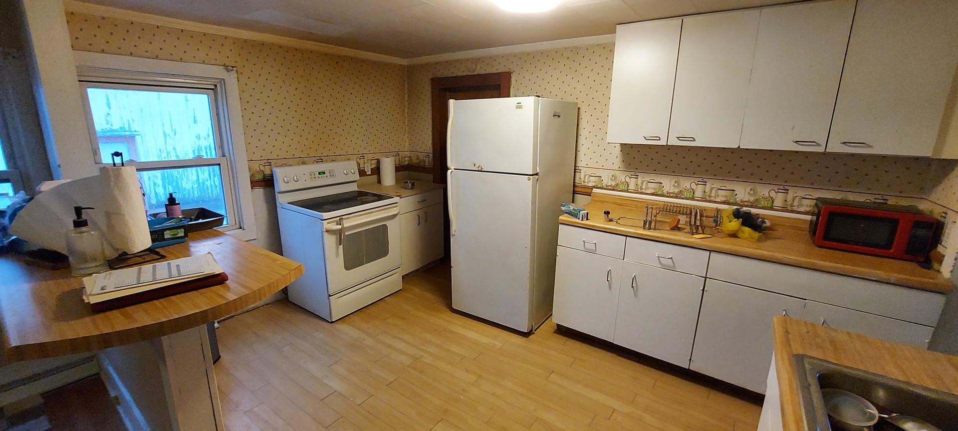 506 State Street New Windsor, IL 61465 - Photo 4 of 10 a kitchen with a refrigerator and a stove top oven