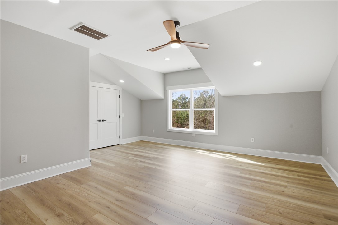 147 McAlister Road West Union, SC 29696 - Photo 31 of 49 This spacious upstairs bedroom features light LVP flooring, offering a versatile living space.