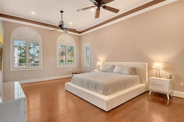 a spacious bedroom with a large bed and a chandelier