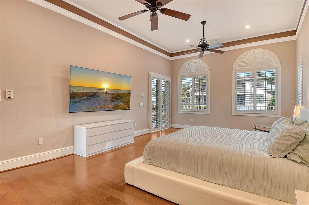 591 Putting Green Lane Longboat Key, FL 34228 - Photo 29 of 68 a bedroom with a bed and a flat screen tv