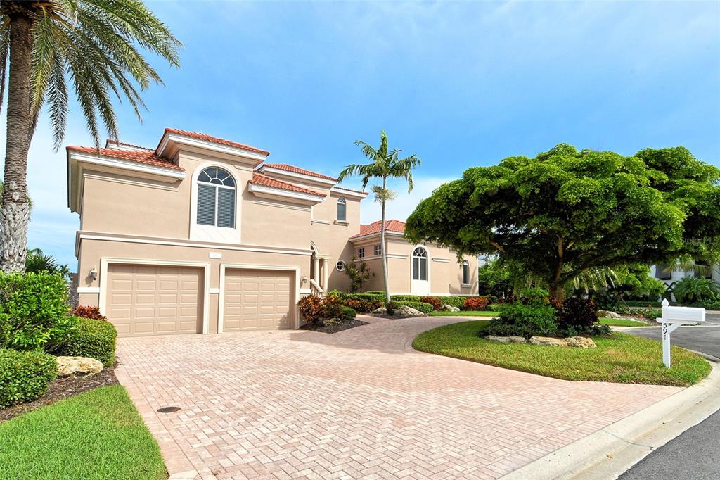 591 Putting Green Lane Longboat Key, FL 34228 - Photo 3 of 68 a front view of a house with a garden