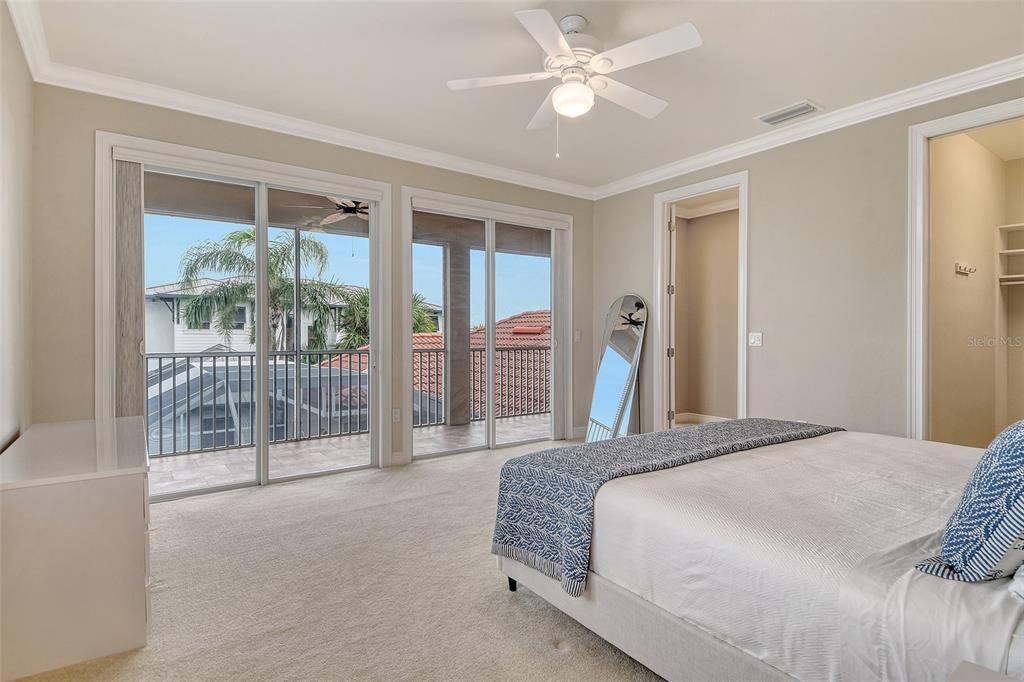 591 Putting Green Lane Longboat Key, FL 34228 - Photo 37 of 68 a spacious bedroom with a large bed and a chandelier