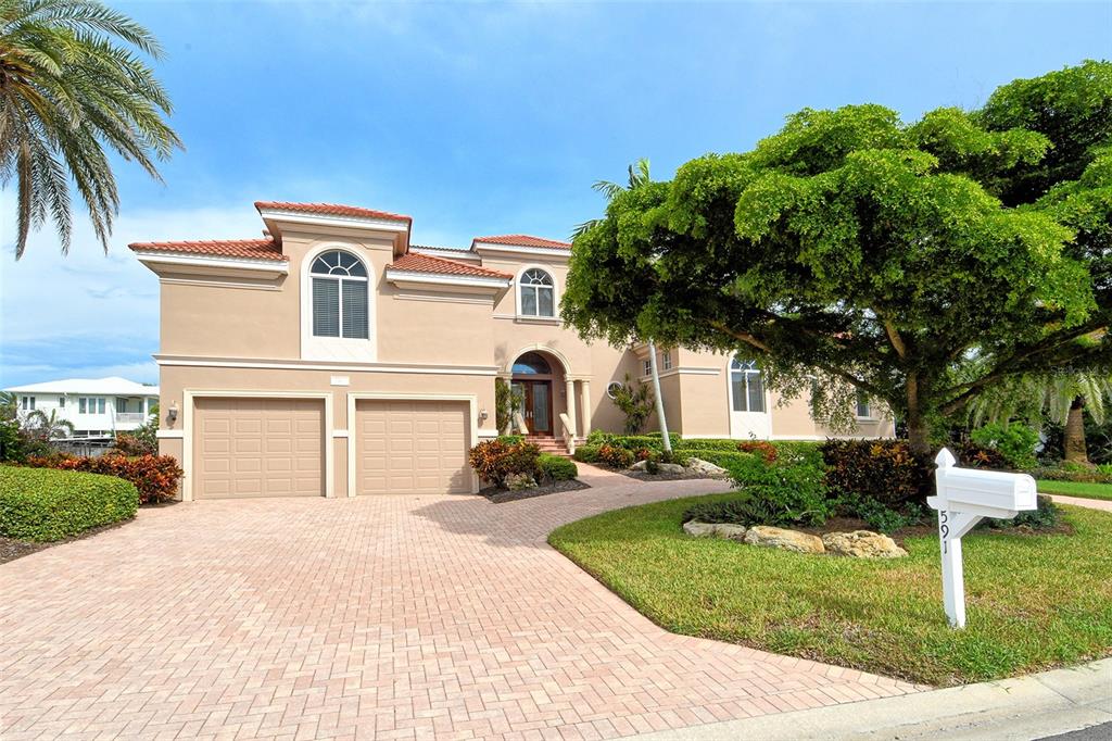 591 Putting Green Lane Longboat Key, FL 34228 - Photo 4 of 68 a front view of a house with a yard