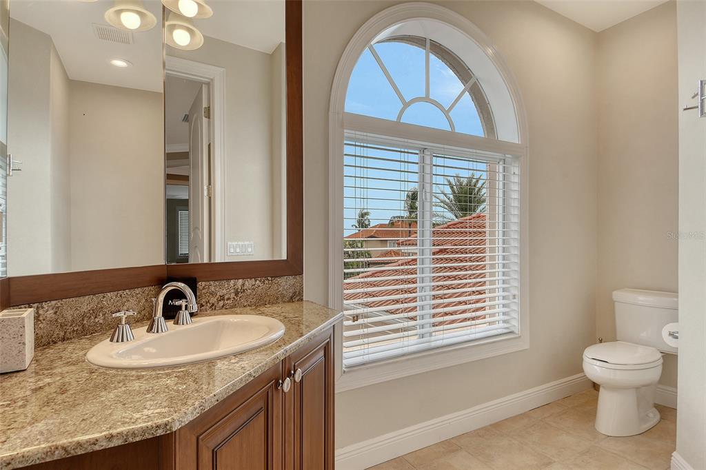591 Putting Green Lane Longboat Key, FL 34228 - Photo 46 of 68 a bathroom with a granite countertop sink a toilet and a window