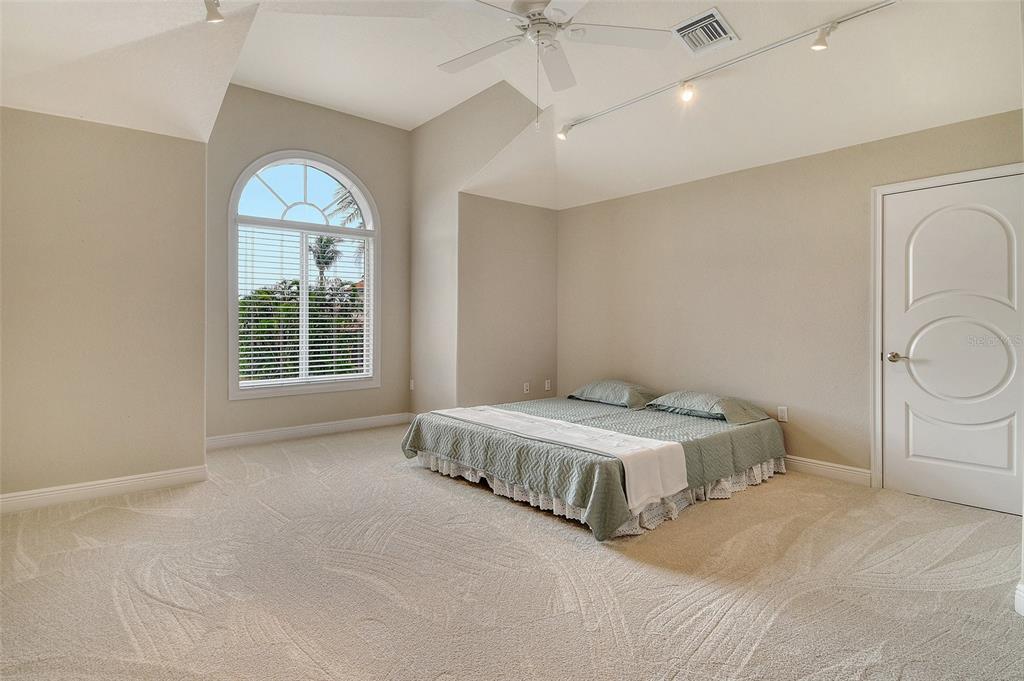 591 Putting Green Lane Longboat Key, FL 34228 - Photo 51 of 68 a spacious bedroom with a bed and a window
