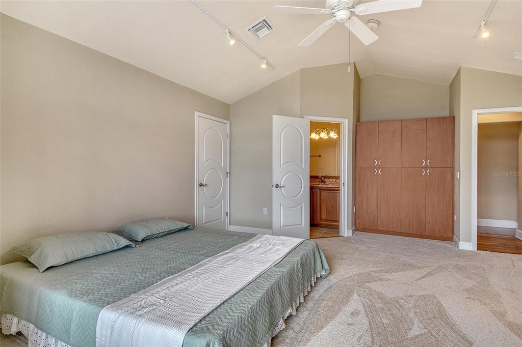 591 Putting Green Lane Longboat Key, FL 34228 - Photo 52 of 68 a bedroom with a bed and a chandelier