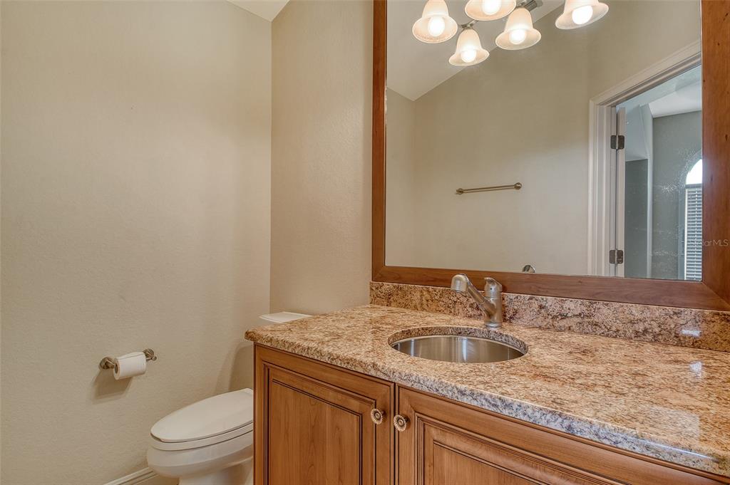 591 Putting Green Lane Longboat Key, FL 34228 - Photo 53 of 68 a bathroom with a granite countertop sink a toilet and a mirror