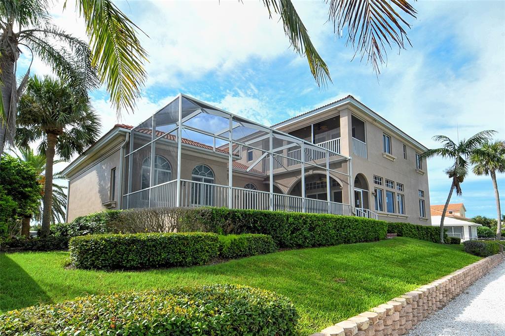 591 Putting Green Lane Longboat Key, FL 34228 - Photo 60 of 68 a front view of a house with a garden