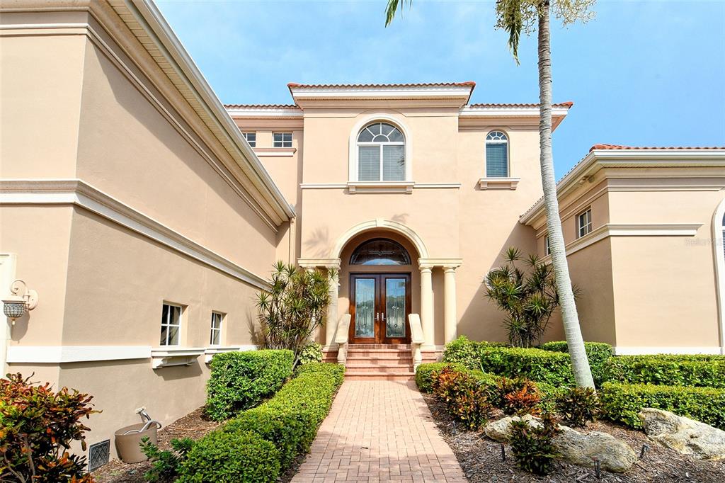 591 Putting Green Lane Longboat Key, FL 34228 - Photo 6 of 68 a front view of a house with garden