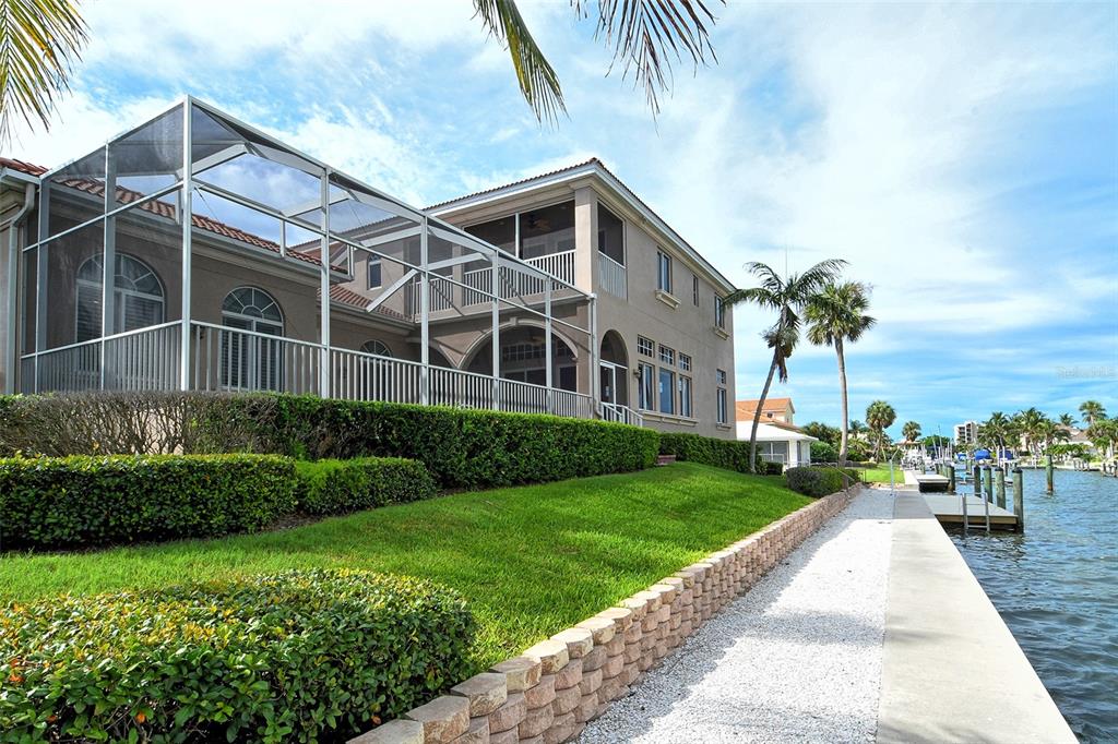591 Putting Green Lane Longboat Key, FL 34228 - Photo 61 of 68 a front view of a house with a yard and potted plants