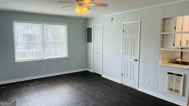 a view of an empty room with window and wooden floor