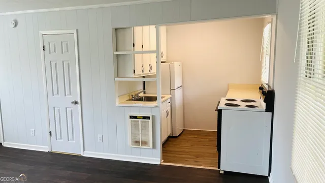 a kitchen with a refrigerator and white cabinets