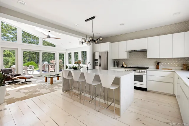 a kitchen with white cabinets and dining table
