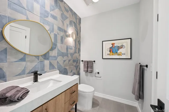 a bathroom with a granite countertop sink mirror vanity and toilet
