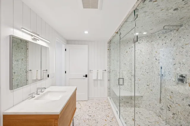 a bathroom with a shower sink and mirror