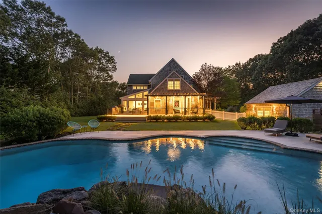 a view of a swimming pool with a patio and a yard with plants