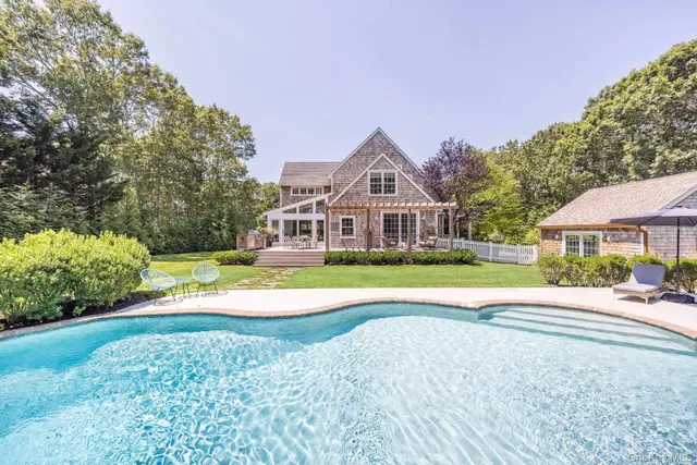 a view of a house with a big yard and large trees