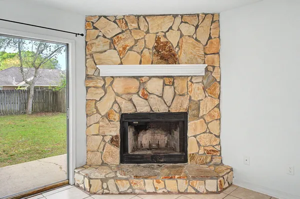 a living room with a fireplace and a floor to ceiling window