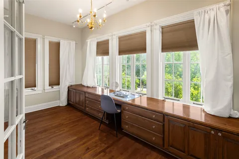 a room with lots of wooden furniture and large windows